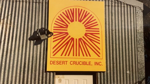 Yellow sign that says Desert Crucible, Inc.